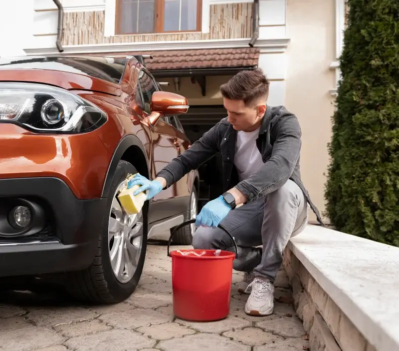 Lavage auto à domicile Morgny-la-Pommeraye : professionnel intervenant sur un véhicule